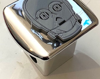 Puede incluir: Una tapa de enganche cromada con un personaje de Star Wars C-3PO impreso en 3D gris fijado en la parte superior.