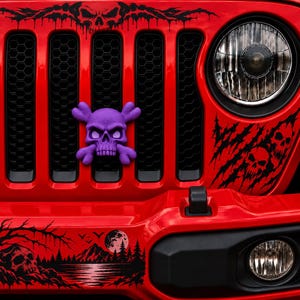 May include: A bright red vehicle front grille featuring a purple skull and crossbones emblem. Black decals include a large skull above the grille, claw marks with skulls near the headlight, and a landscape scene with a moon on the bumper.