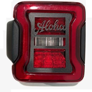 May include: Red taillight with a black overlay that says "Aloha" in a stylized font.