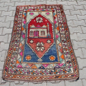 Pu&ograve; includere: Un tappeto da preghiera turco colorato con un design tradizionale che presenta una moschea e motivi geometrici. Il tappeto &egrave; fatto di lana e ha un bordo a frange.