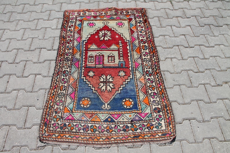 Pu&ograve; includere: Un tappeto da preghiera turco colorato con un design tradizionale che presenta una moschea e motivi geometrici. Il tappeto &egrave; fatto di lana e ha un bordo a frange.