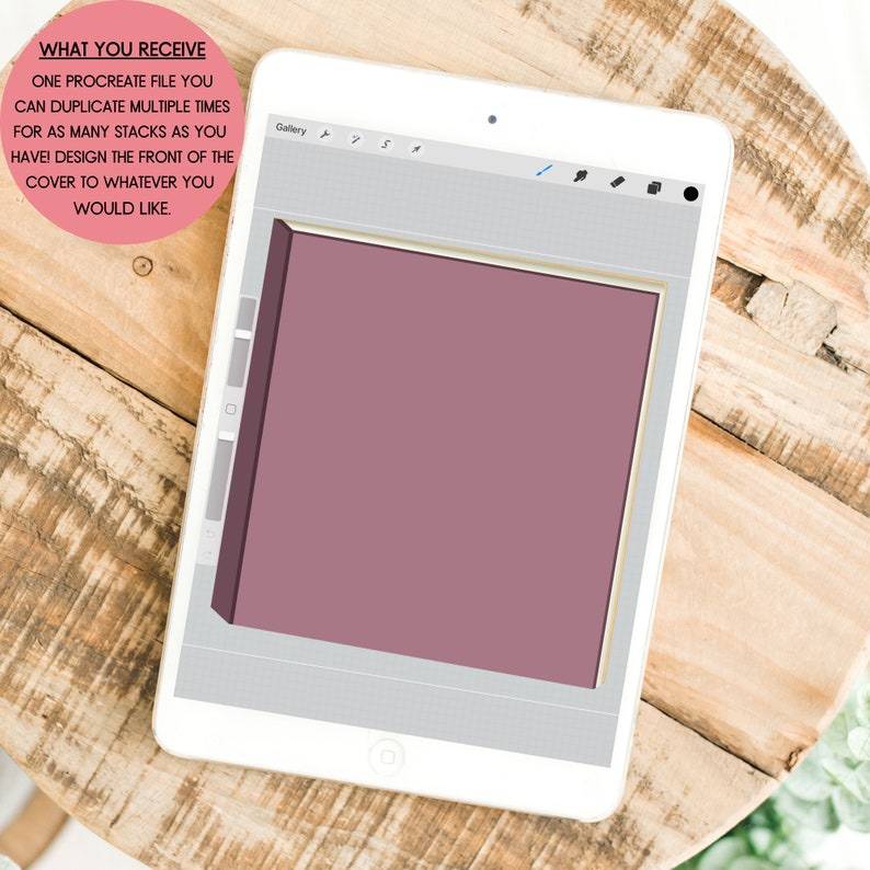 Może przedstawiać: Biały tablet wyświetla cyfrowy projekt okładki książki w pliku Procreate. Okładka ma stonowany kolor malinowy ze złotą obw&oacute;dką. Tekst na tablecie brzmi: "CO OTRZYMUJESZ...ZAPROJEKTUJ PRZ&Oacute;D OKŁADKI JAK CHCESZ."