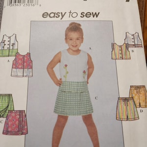 May include: A Simplicity sewing pattern envelope, number 8723, size BB 5, 6, 7, 8. The front features illustrations of various sleeveless tops, skirts, and shorts, with a central image of a child wearing a white top with floral embroidery and a green gingham skirt.