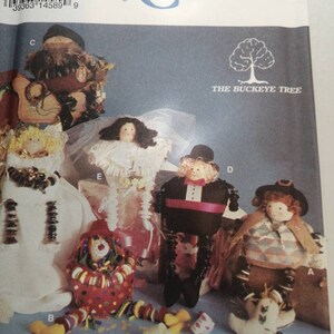 May include: A Simplicity Crafts pattern for making five different dolls. The dolls are a bride, a groom, a clown, a scarecrow, and a cowboy. The pattern is titled "The Buckeye Tree".