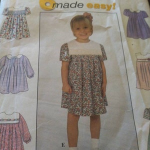 May include: A sewing pattern for a girl's dress. The pattern includes instructions for making a dress with a white collar and short sleeves. The dress is shown in a floral print. The pattern is labeled "Simplicity made easy!" and includes a size chart.