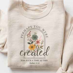 May include: Beige sweatshirt with a floral design and the text "Perhaps you were created for such a time as this Esther 4:14"
