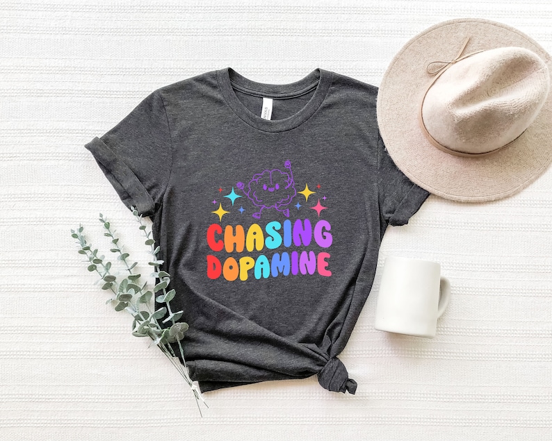 May include: A dark gray t-shirt with a rainbow graphic of a cartoon brain with the text "Chasing Dopamine".