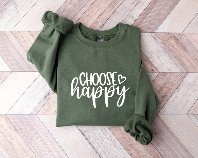 May include: A green sweatshirt with the text "CHOOSE happy" in white lettering with a small heart symbol.
