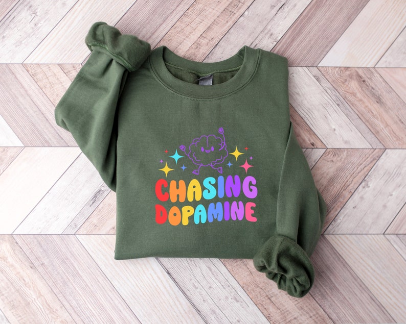 May include: A green sweatshirt with a rainbow graphic of a brain with the text "Chasing Dopamine".