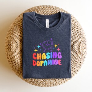 May include: A dark gray t-shirt with a rainbow graphic of a brain with the text "Chasing Dopamine".