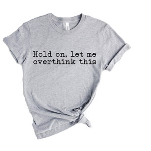 May include: Gray t-shirt with the text "Hold on, let me overthink this" printed in black.