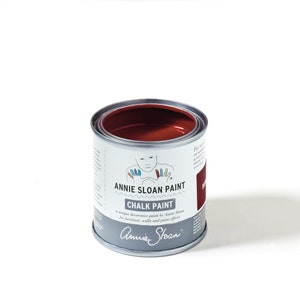 May include: A round metal can of Annie Sloan Chalk Paint in the color  'Red 08'. The can has a white label with the Annie Sloan logo and the text 'Annie Sloan Chalk Paint' and 'A unique decorative paint by Annie Sloan for furniture, walls and paint effects'.