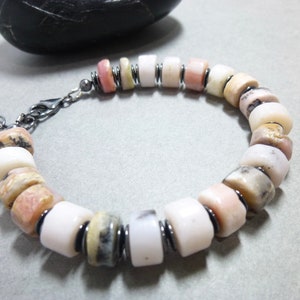 This Pale pink Peruvian Opal bracelet features chubby rondelle stones with natural gray Hematite accent stone disks. It closes with an oxidized sterling silver lobster clasp and has a tiny pink Peruvian opal stone dangle that hangs from the clasp.