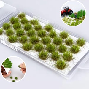 Könnte beinhalten: Ein transparenter Plastikbehälter gefüllt mit 30 kleinen, grünen, vorgeschnittenen, selbstklebenden Grasbüscheln für den Modellbau oder die Miniatur-Landschaftsgestaltung.