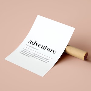 Peut inclure: Impression blanche avec le mot "aventure" en noir gras et sa d&eacute;finition. L'impression est appuy&eacute;e contre un tube en carton marron, sur un fond rose clair. Le texte est en police sans-serif.
