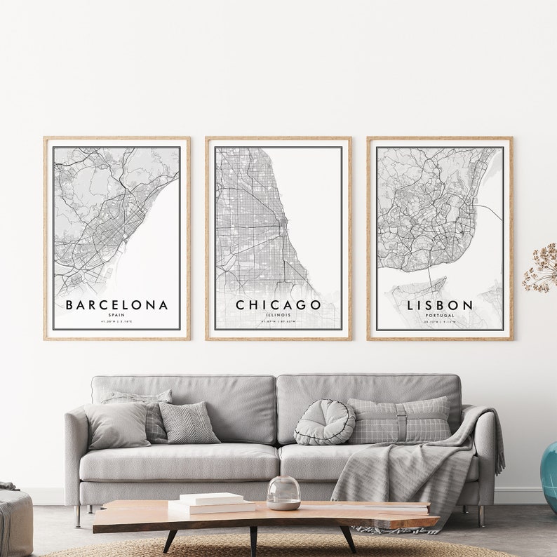 May include: Three black and white city maps in wooden frames, with the city names "Barcelona, Spain", "Chicago, Illinois", and "Lisbon, Portugal" printed below each map.