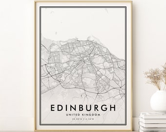 May include: A black and white map print of Edinburgh, Scotland, with the city name and coordinates printed below the map. The map is framed in a gold frame and is displayed on a white wall.