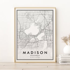 Puede incluir: Impresión de un mapa de Madison, Wisconsin en blanco y negro con el nombre de la ciudad y las coordenadas en la esquina inferior derecha. El mapa muestra las calles y los lagos de la ciudad.
