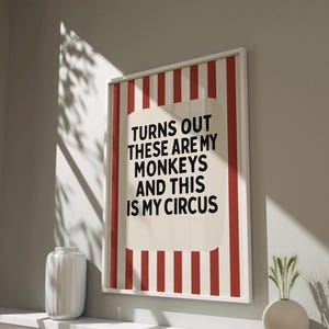 May include: A white framed print with red and white stripes. The print has the text "Turns out these are my monkeys and this is my circus" in black.
