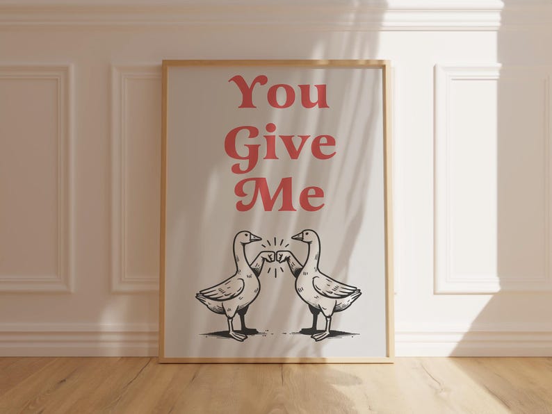 May include: A framed print with a white background and the text "You Give Me" in red. Two black and white illustrations of geese facing each other with their fists bumping.