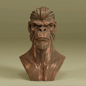May include: A bronze-colored bust of a gorilla with detailed facial features and a stern expression. The sculpture has a textured surface with vertical lines on the neck and chest, and a stylized hairstyle.
