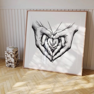 May include: Black and white line drawing of two hands forming a heart shape around a smaller pair of hands.