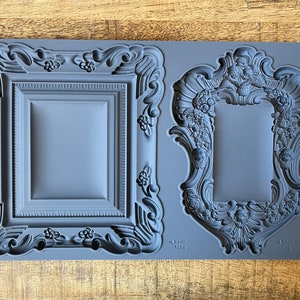 May include: A gray silicone mold with two ornate frame designs. The mold is labeled "Frames IOD" and includes measurements in inches.