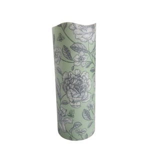 Candela a colonna in cera senza fiamma a LED con fiori romantici su uno sfondo verde tenue