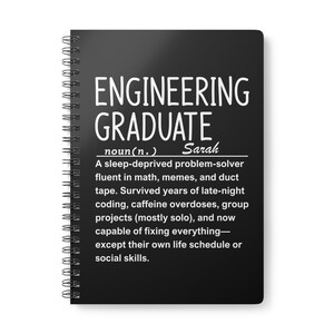 Könnte beinhalten: Schwarzes Spiralnotizbuch mit weißem Text. Auf dem Cover steht "ENGINEERING GRADUATE" über einer Definition eines Ingenieurabsolventen, einschließlich des Namens "Sarah". Die Definition beschreibt einen schlaflosen Problemlöser.