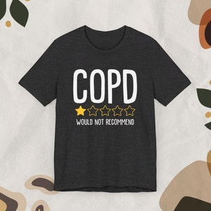 May include: A dark gray t-shirt with the text "COPD" in white and a one-star rating with the text "Would not recommend" in white.