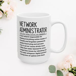 Op de afbeelding: Witte keramische mok met de tekst "NETWORK ADMINISTRATOR" en een definitie. De definitie beschrijft de rol van een netwerkbeheerder, inclusief verantwoordelijkheden en kenmerken.