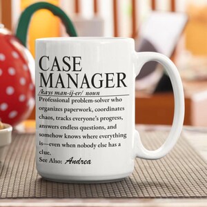 Può includere: Una tazza in ceramica bianca con testo stampato in nero che definisce un case manager come un risolutore di problemi professionale che organizza scartoffie, coordina il caos, segue i progressi e risponde alle domande, con See Also: Andrea.