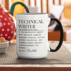 May include: White ceramic mug with a black handle and rim. The mug features the text "TECHNICAL WRITER" with a definition below. The mug also includes the name "Charlotte".