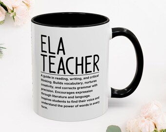 Puede incluir: Taza de cerámica blanca con interior y asa negros. La taza presenta el texto "ELA TEACHER" en letras negras grandes, con una descripción del rol de un profesor de ELA debajo. La taza está rodeada de flores blancas.