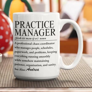 Puede incluir: Una taza de cerámica blanca con texto impreso en negro que define a un Practice Manager como un coordinador de caos profesional que gestiona personas, horarios, papeleo y problemas, manteniendo la paciencia, la organización y la cordura. Ver también: Andrea.