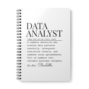 Peut inclure: Un cahier blanc à spirales avec le texte "DATA ANALYST" en noir. Une définition du rôle est imprimée en dessous. Le texte comprend "See Also: Charlotte".