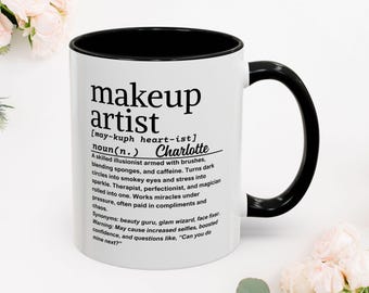 Può includere: Tazza in ceramica bianca con interno e manico neri. La tazza presenta il testo "makeup artist" in grassetto nero, insieme a una definizione e al nome "Charlotte". Un regalo perfetto per i truccatori.