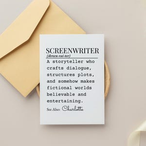 May include: A white card with the definition of "SCREENWRITER" in black text, including the phonetic pronunciation. The card is on a wooden surface, with a tan envelope in the background. The definition describes a storyteller.