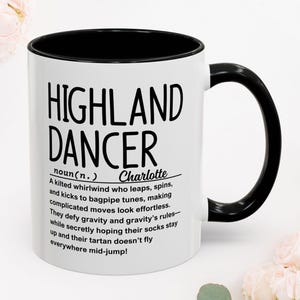 Peut inclure: Un mug en céramique blanche avec un intérieur et une anse noirs. L'extérieur présente un texte noir qui indique : HIGHLAND DANCER noun(n.) Charlotte. A kilted whirlwind who leaps, spins, and kicks to bagpipe tunes, making complicated moves.
