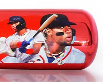 May include: A baseball bat with a blue handle that fades into a red barrel. The barrel features the name "RONALD ACUÑA JR." and a player illustration.