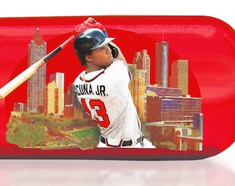 May include: A red baseball bat with a white design. The bat is a limited edition, number 12 of 100. The design features the name "Ronald Acuna Jr #13" and the text "2023 Season. First player in history with 20+ HR 40+ SB 50+ RBI before the All-Star Break."