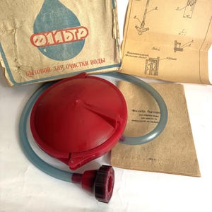 May include: A vintage water filter kit with a red plastic filter, a blue tube, and a cardboard box. The box has a blue water drop logo with Cyrillic text. Includes a diagram and instruction sheet.