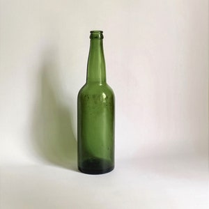 Old glass bottle. Collectible German bottle of the 40s. Vintage vessel made of green glass.