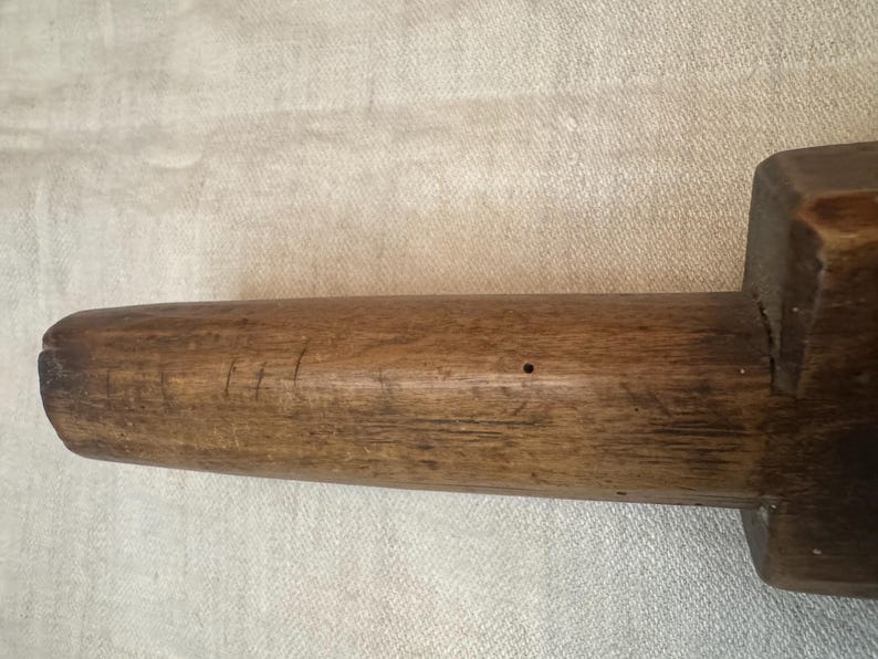 Pu&ograve; includere: Un primo piano di un mattarello di legno con una superficie liscia e marrone. Il mattarello ha un manico leggermente arrotondato ed &egrave; fatto di un unico pezzo di legno.