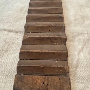 Pu&ograve; includere: Un'asciugatrice per vestiti in legno vintage con pi&ugrave; listelli. L'asciugatrice &egrave; in legno marrone scuro e ha un aspetto rustico.