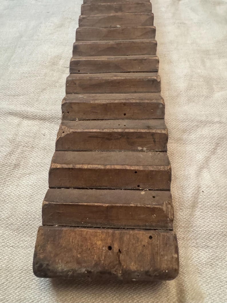Pu&ograve; includere: Un'asciugatrice per vestiti in legno vintage con pi&ugrave; listelli. L'asciugatrice &egrave; in legno marrone scuro e ha un aspetto rustico.