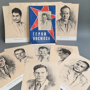 Puede incluir: Una colección de impresiones de retratos antiguos con bocetos de varias personas con uniformes militares, acompañadas de un libro azul central titulado GEROI KOSMOCA con un gráfico de estrella roja grande y un retrato de un hombre.