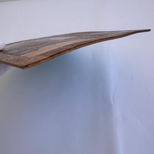 Peut inclure: Planche de service incurv&eacute;e en bois avec un motif de grain de bois brun fonc&eacute; et beige. La planche a une finition lisse et polie et un bord l&eacute;g&egrave;rement sur&eacute;lev&eacute;. La planche mesure environ 46 cm de long.