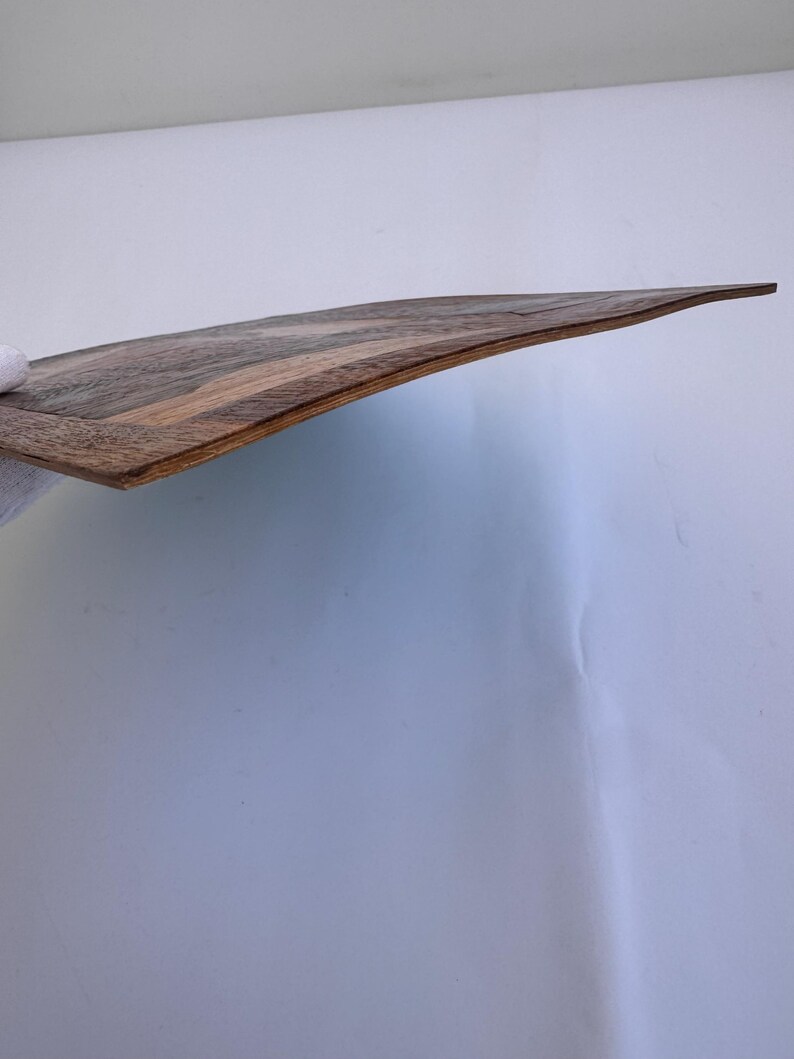 Peut inclure: Planche de service incurv&eacute;e en bois avec un motif de grain de bois brun fonc&eacute; et beige. La planche a une finition lisse et polie et un bord l&eacute;g&egrave;rement sur&eacute;lev&eacute;. La planche mesure environ 46 cm de long.