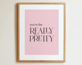 May include: A framed print with a pink background and black text that reads "you're like REALLY PRETTY".